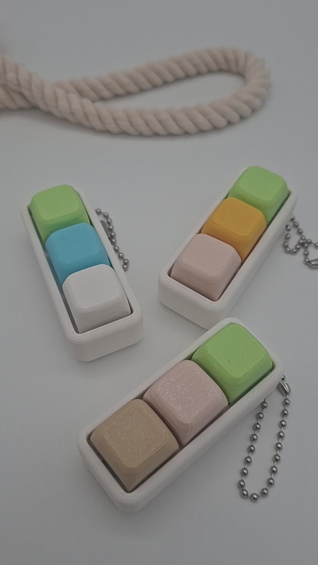Pastellfarbener Keyboard Klicker mit drei Keycaps auf weißem Gehäuse als sensorisches Fidget für Konzentration und Entspannung.